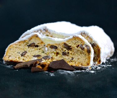 Angeschnittener Schoko-Mandelstollen mit einigen Brocken Zartbiiter-Schokolade im Vordergrund
