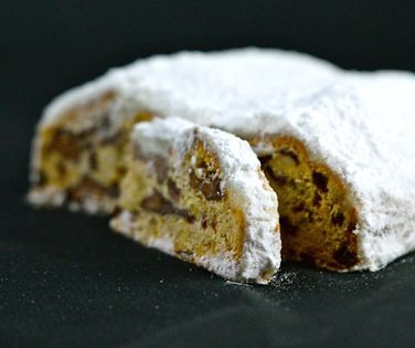 Angeschnittener Nougat-Rosinenstollen mit halber Scheibe im Vordergrund