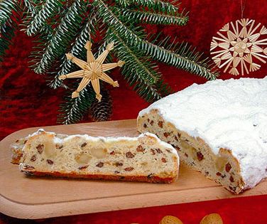 Angeschnittener Butter-Rosinenstollen mit feinen Marzipanstücken auf Holzplatte