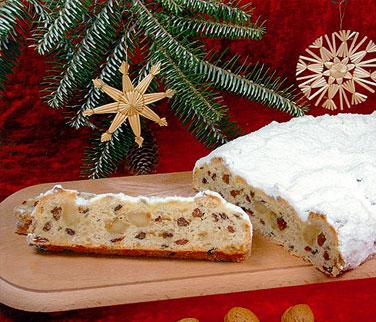 Angeschnittener Butter-Rosinenstollen mit feinen Marzipanstücken auf Holzplatte