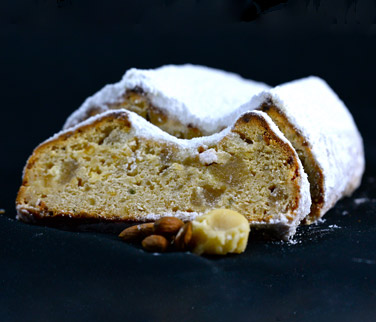 Angeschnittener Mandelstollen mit Marzipan und Dekoration